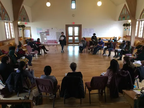 People sitting in a circle at a popular education training in a local church.