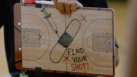Find your shot! Basketball tactic board showing a bandage and syringe at center court.