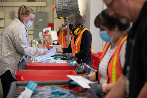 Four elections employees traying ballots 