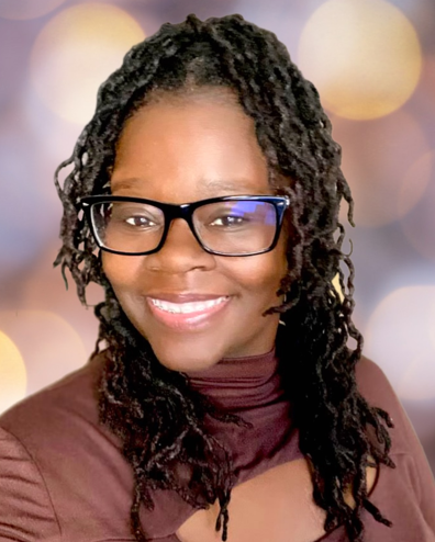 woman with glasses and long black locs. brown top on.