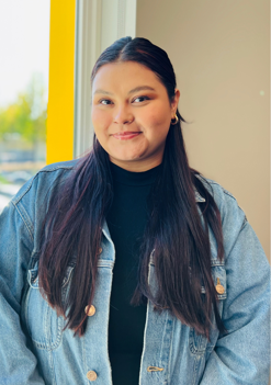 woman with long black hair and denim jacket with black top on