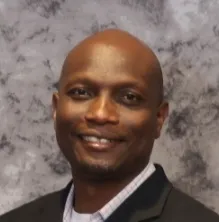 In a headshot, Michael stands smiling.