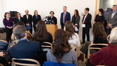 Chair Jessica Vega Pederson stands at dais alongside other elected officials and community leaders, including Mayor Ted Wheeler, Lori Stegmann, Julia Brim-Edwards and Mayor Ted Wheeler