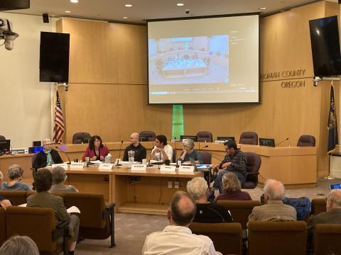 Panelists Mary King, Commissioner Sharon Meieran, Melanie Plaut, John Talberth, Chris Voss, and John Wasiutynski sit at the dias at the Multnomah Building boardroom.