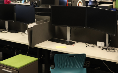 Photo of a group of empty workspaces with computers.