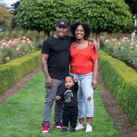 Portrait of black parents and a baby in a rose garden