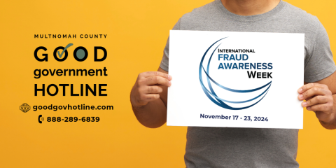 A person holding a sign that says “International Fraud Awareness Week, November 17-23, 2024 ” with the Good Government Hotline logo to the left side, as well as the website goodgovhotline.com, and the hotline number 888-289-6839