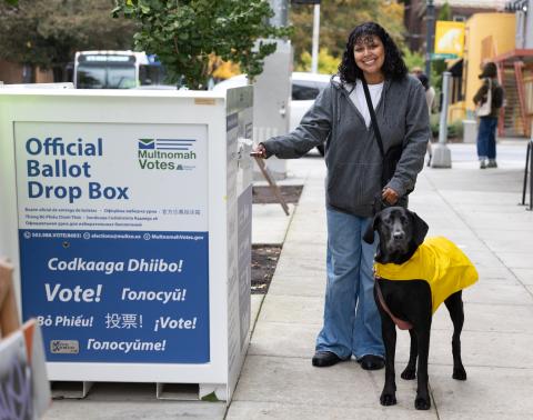 voter with a dog on a leash delivering a ballot