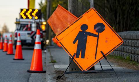 an orange construction sign indicating stop ahead