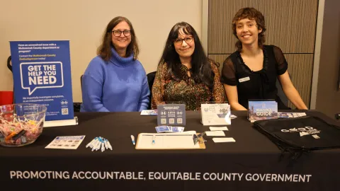 three people behind table at MLK Tribute event