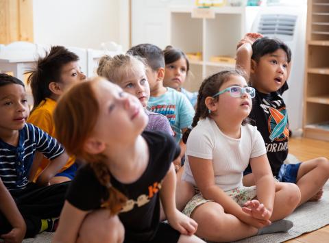 Preschool students looking attentively at their teacher