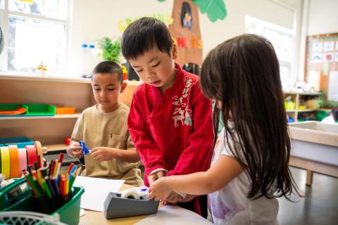 Preschool students working together on a craft