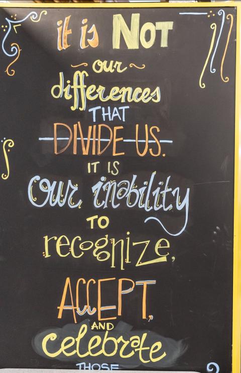 Chalk board with colored writing that reads "it is not our differences that divide us. It is our inability to recognize, accept, and celebrate those.