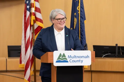 Commissioner Meghan Moyer standing at a speakers podium.