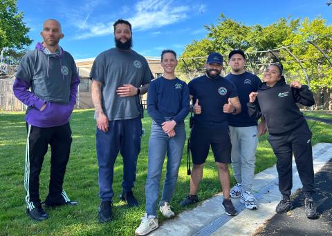six members of the Juvenile Services Division of Department of Community Justice stand in detention's outside recreation area