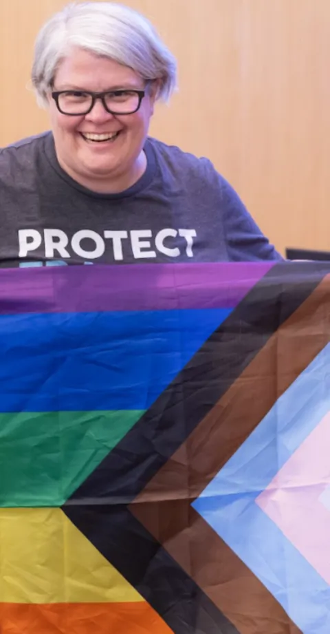 Commissioner Meghan Moyer holding a Pride Flag