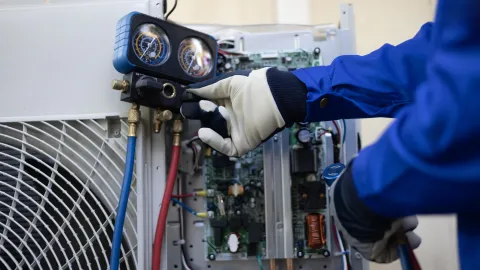 Technician checking air conditioner unit