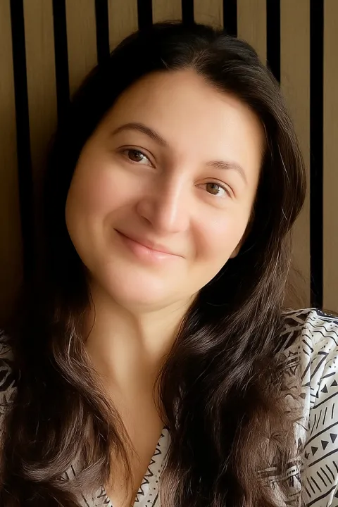 Anna smiling with a white and black patterned shirt on