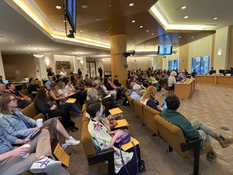 a large group gather in the Board room to honor volunteers