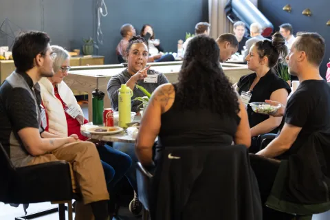 A group of people talks at a table.