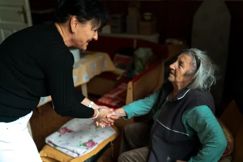 Un cuidador saluda a un residente con Alzheimer.