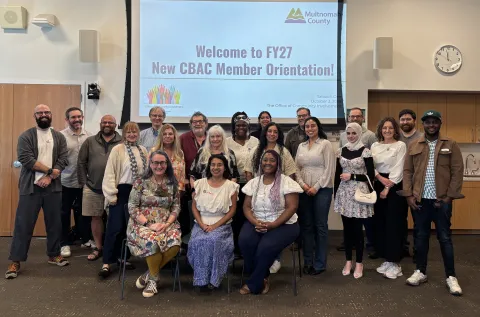 New CBAC Members gather in front of a slideshow presentation at FY28 Orientation and Onboarding Session held at the Midland County Library