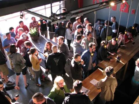 La sala de degustación y el salón de champán de Gigantic Brewing Company estaban repletos de clientes que disfrutaban de animadas conversaciones y diversas cervezas.