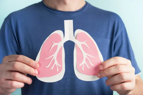 close up of man holding paper lungs